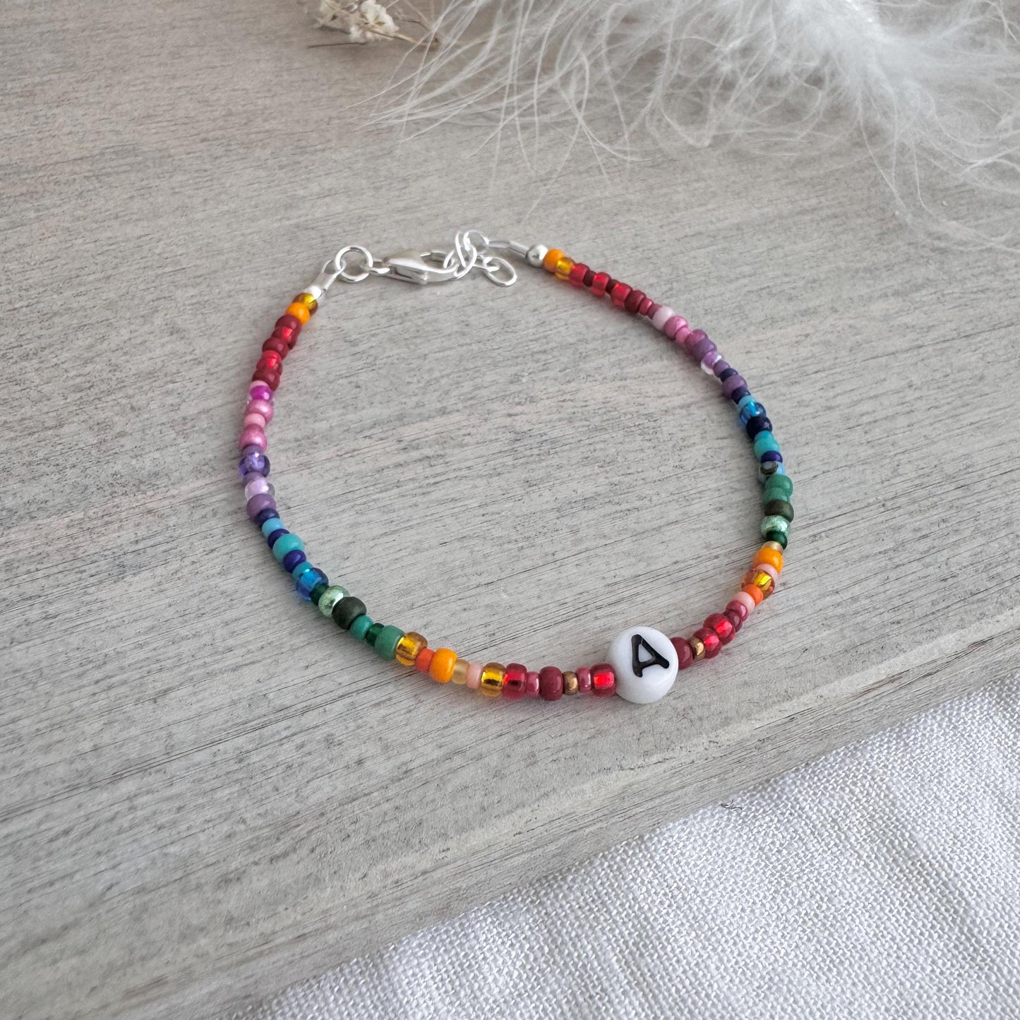 Personalised Rainbow Bracelet with glass seed beads in rainbow colours and a Czech glass letter