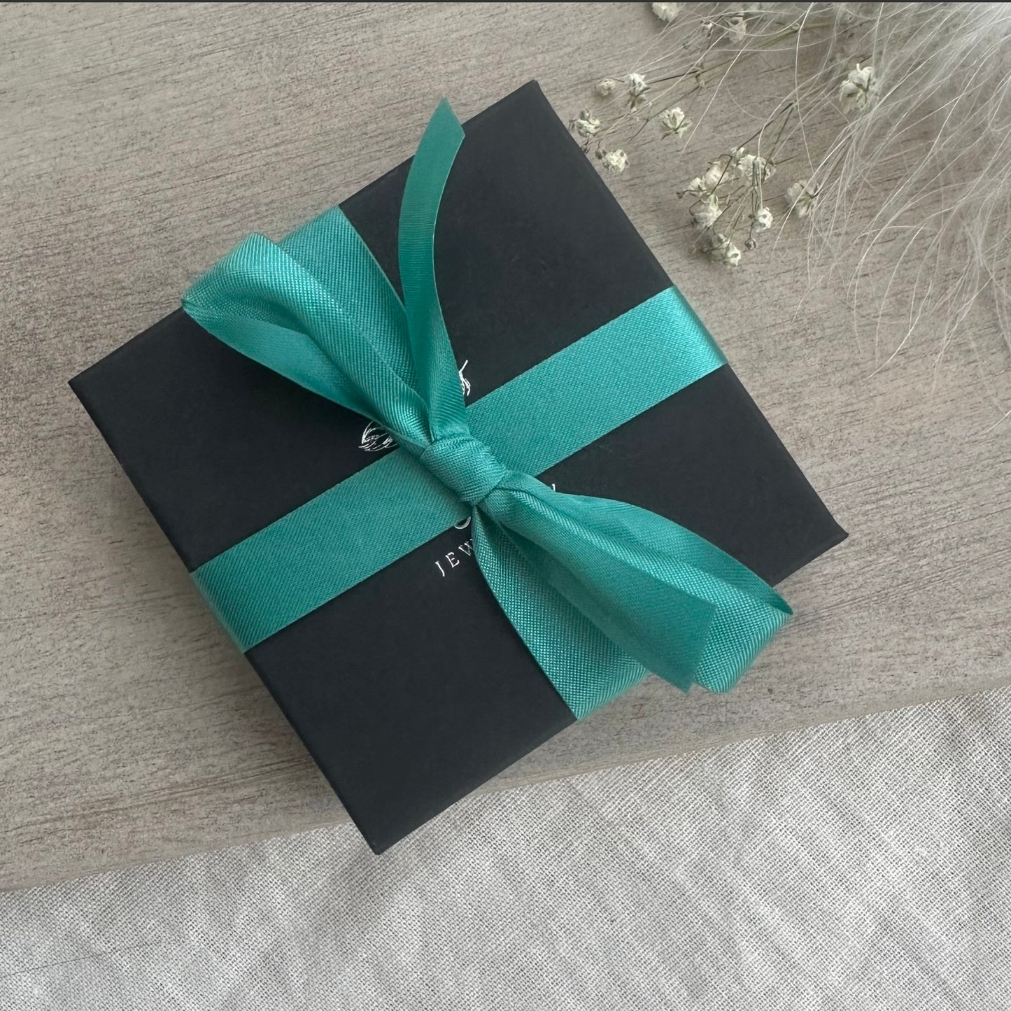 a black and blue gift box with a green ribbon